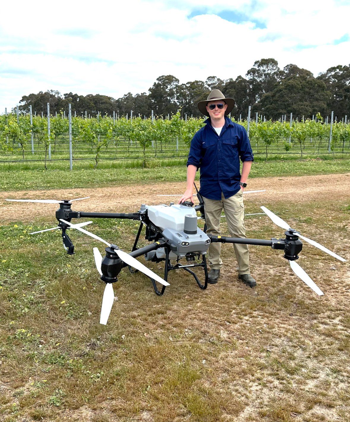 Sean Maynard beside the DJI Agras T50 spray drone in a Margaret River vineyard
